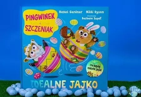 Okładka książki pod tytułem 'Idealne jajko' przedstawiająca głównych bohaterów pingwinka i szczeniaczka znajdujacych się w kolorowych pisankach.